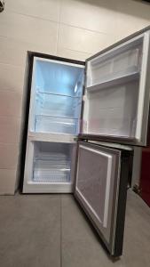 an empty refrigerator with its door open in a room at Agli Archi Eco House in Chieti