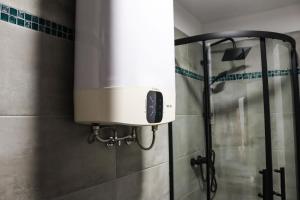 a water heater on the wall of a shower in a bathroom at Ospitaria-Suite Sant'Anastasia in Verona