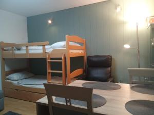 Cette petite chambre comprend des lits superposés et une chaise. dans l'établissement Komplette Wohnung Schwarzwaldpforte Casa BaLi direkte Buchung möglich keine Freigabe mehr erforderlich, à Bad Liebenzell