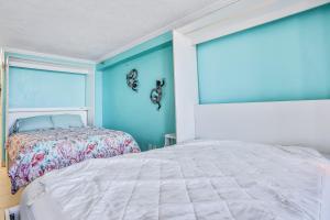 una camera da letto con un letto e una parete blu di Daytona Seagull's Nest Harbour Beach 608 a Seabreeze Altre 9 foto