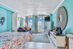 una camera da letto con un letto, un divano e una TV di Daytona Seagull's Nest Harbour Beach 608 a Seabreeze