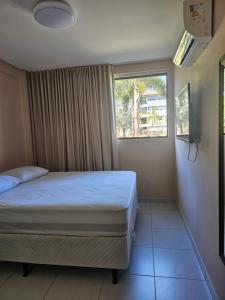 een slaapkamer met een bed en een raam bij Beach Class Eco Life Figueira in Porto De Galinhas +31 foto's