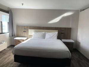 a bedroom with a large bed and two night stands at Sisk Hotel in Modesto