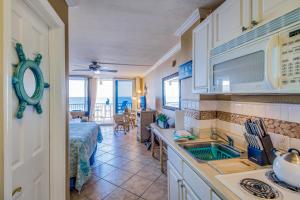 a kitchen with a sink and a room with a bed at Daytona Beach in Daytona Beach