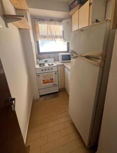 a kitchen with a white refrigerator and a stove at Miramar 19 in Miramar