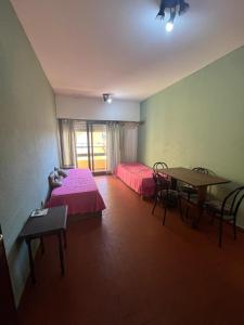 a room with two beds and a table and a table and chairs at Miramar 19 in Miramar