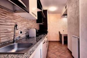 een keuken met een spoelbak en een aanrechtblad bij Cristian Case Vacanza in Colonna