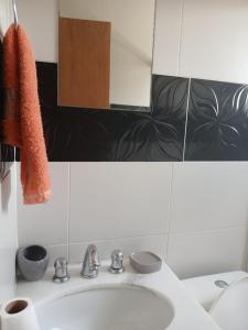 a bathroom with a sink and a mirror at Residencial Daitx in Capão da Canoa +13 photos