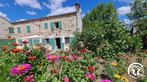 een tuin met bloemen voor een stenen huis bij Guyor in Le Bez