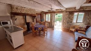 een keuken en woonkamer met een bank en een tafel bij Guyor in Le Bez