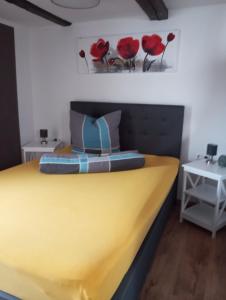 a bedroom with a yellow bed with red flowers on the wall at Gästeoase einfach wohl fühlen in Wolfhagen