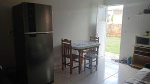 a kitchen with a refrigerator and a table and chairs at Residencial Daitx in Capão da Canoa