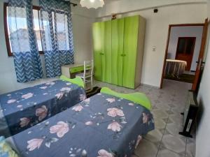 een slaapkamer met 2 bedden en een groene deur bij Friendship Dorms Hostel in Shkodër
