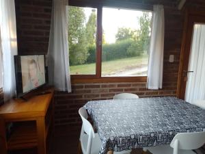 a dining room with a table and a window at Apartamento Zorzal in Lago Puelo