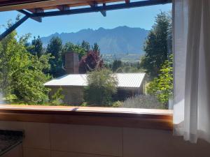 a window with a view of a house at Apartamento Zorzal in Lago Puelo