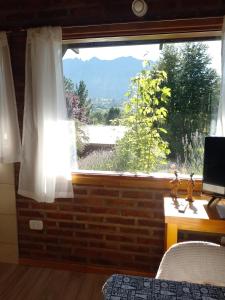a bedroom with a window with a view of a mountain at Apartamento Zorzal in Lago Puelo