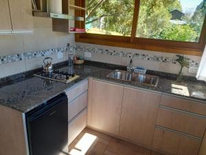 a kitchen with a sink and a stove and a window at Apartamento Zorzal in Lago Puelo
