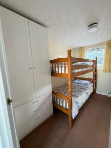 a small bedroom with a bunk bed and a cabinet at 92 Blueberry Lodge - Sea Views in Westward Ho