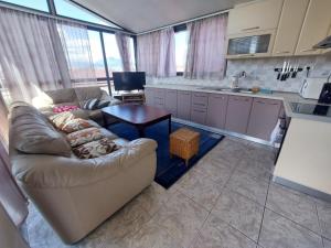 a living room with a couch and a table in a kitchen at Friendship Dorms Hostel in Shkodër +33 photos