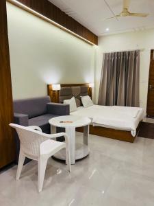 een slaapkamer met een bed, een bank en een tafel bij Rishikesh Sadan Studio- Best stay in Tapovan , Guests Favourite,Travellers Delight!! in Rishīkesh