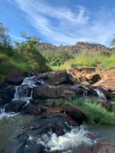 a stream of water with rocks and grass at Pousada em Itupeva in Itupeva