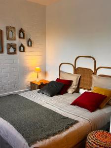 een slaapkamer met een groot bed met kussens erop bij Villa d’ô in Majikavo Koropa