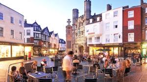 a group of people sitting at tables on a city street at The idyllic Acorn Lodge in Canterbury