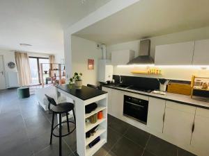 a kitchen with white cabinets and a black counter top at Les pieds dans l'eau in Thonon-les-Bains