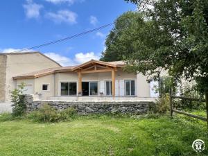 a house with a stone wall at Gite du tatou in Roquefeuil