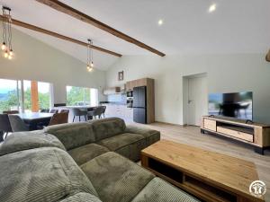a living room with a couch and a tv at Gite du tatou in Roquefeuil