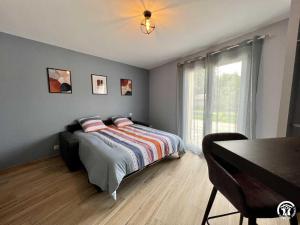 a bedroom with a bed and a table and a window at Gite du tatou in Roquefeuil