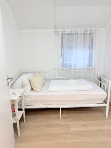 un lit blanc dans une chambre avec une fenêtre dans l'établissement Fichtenblick, à Selb