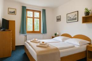 een slaapkamer met een bed met twee handdoeken erop bij REJVÍZ 1 Hotel & Spa in Rejvíz