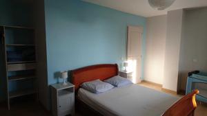 une chambre avec un lit avec un mur bleu dans l'établissement Le grand gite de souels, à Almayrac