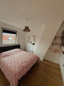 a bedroom with a bed and a window and a staircase at Appartement cocooning proche de lille in Loos
