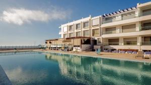 a swimming pool in front of a building at Sea & Pool View Apt 1 in Aourir