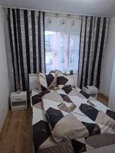 a bedroom with a bed with a black and white comforter at Lily Ap in Lupeni
