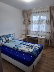 a bedroom with a bed and a sink and a window at Lily Ap in Lupeni