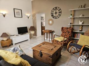 a living room filled with furniture and a clock on the wall at Roumanieu le gite in Saint-Gauzens