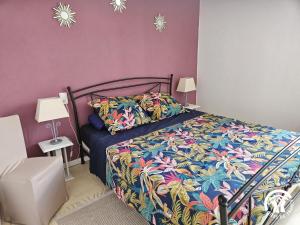 a bedroom with a bed with a colorful comforter at Roumanieu le gite in Saint-Gauzens