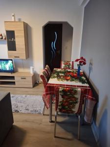 a dining room table with a table cloth on it at Lily Ap in Lupeni