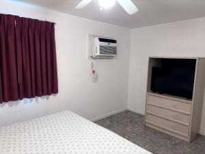 a bedroom with a bed and a tv and a window at Apollo Motel in Wildwood Crest