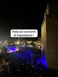 een menigte mensen bij een concert 's nachts bij Mamas in Oristano