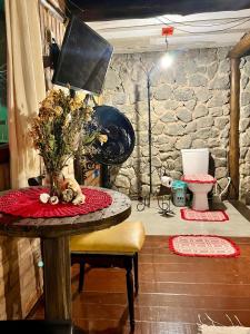 a room with a table with a vase of flowers on it at Pousada Magia da Mata in Trindade