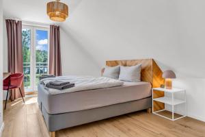 a bedroom with a bed and a window at Haus am Seeufer mit Badestelle in 200m, große Sonnenterrasse, umzäunter Garten, Hunde willkommen in Rheinsberg +44 photos