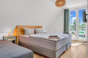a bedroom with a bed and a large window at Haus am Seeufer mit Badestelle in 200m, große Sonnenterrasse, umzäunter Garten, Hunde willkommen in Rheinsberg