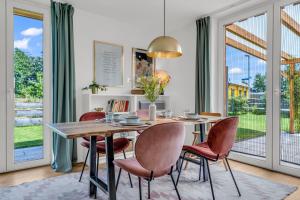 a dining room with a table and chairs at Haus am Seeufer mit Badestelle in 200m, große Sonnenterrasse, umzäunter Garten, Hunde willkommen in Rheinsberg