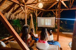 a group of girls sitting in a room watching a screen at Tongo Hill Cottages in Moalboal