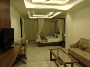 - un salon avec un lit et un canapé dans l'établissement Hotel Kalyan's - Mansingh Inn, à Khambhāliya