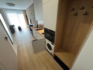 een kleine keuken met een deur naar de woonkamer bij Żurawie II Popiełuszki 2A 51 in Gdańsk